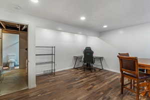 Home office featuring a textured ceiling, recessed lighting, and dark wood-style flooring