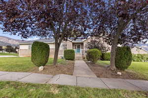 View of front of home with a front lawn, brick siding, and a mountain view