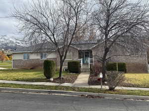 View of front of home featuring a front yard and brick siding
