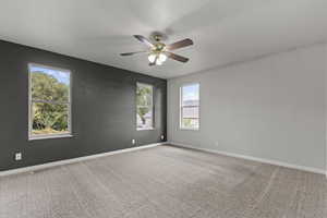 Unfurnished room featuring light carpet and a ceiling fan
