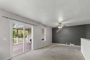 Carpeted empty room featuring a textured ceiling and ceiling fan