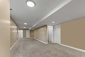 Finished basement with carpet floors and recessed lighting