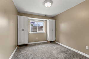 Unfurnished bedroom with carpet floors and baseboards