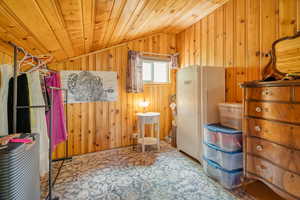 Bedroom featuring lofted ceiling, wood walls, and wood ceiling