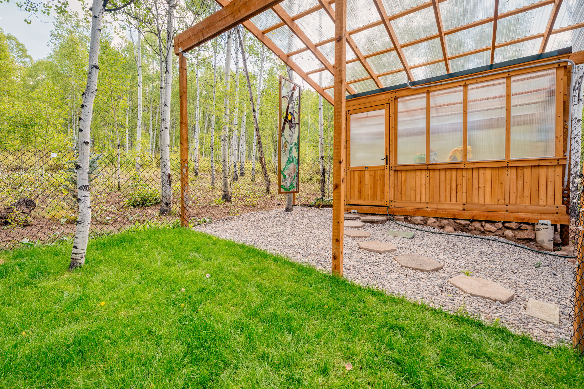 View of yard with a greenhouse and an outbuilding