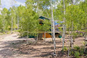 Rear view of house with stairway and a wooden deck