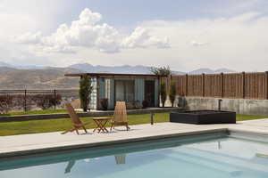 View of pool featuring a patio area, a mountain view, and an outbuilding