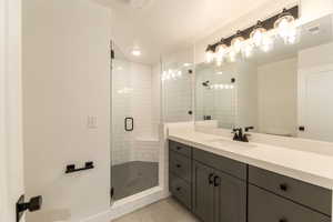 Bathroom with vanity, a shower stall, light tile patterned flooring, and recessed lighting