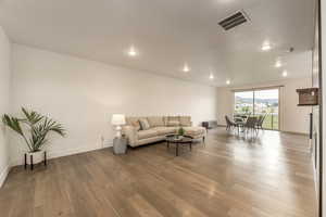 Living room with light wood-type flooring, a mountain view, and recessed lighting