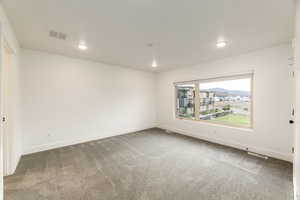 Unfurnished room with light colored carpet and recessed lighting