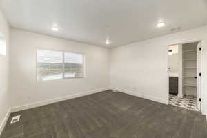 Unfurnished bedroom featuring dark carpet and recessed lighting