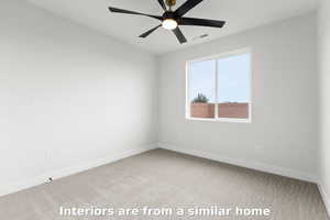 Carpeted spare room featuring baseboards and a ceiling fan