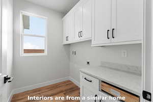 Laundry area with washer hookup, dark wood-style flooring, electric dryer hookup, and cabinet space