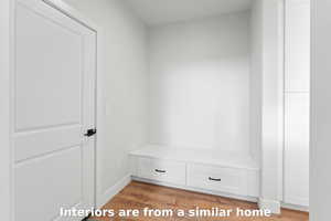 Mudroom featuring wood finished floors and baseboards
