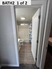 Full bathroom featuring vanity, shower/bathtub combination with dark wood-type flooring