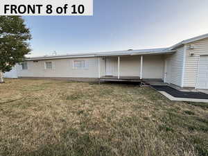 View of front of home with a front lawn, a metal roof, and a deck
