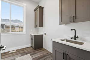 Laundry room featuring a mountain view, cabinet space, dark wood-style floors, and hookup for a washing machine