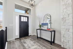 STAGED - Entrance foyer with wood finished floors and a high ceiling