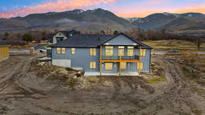 Back of house with a patio, a Cherry Peak mountain view, and board and batten siding