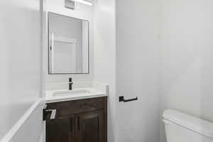 Half bath featuring vanity and toilet