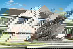 View of front of property featuring driveway, board and batten siding, and a garage