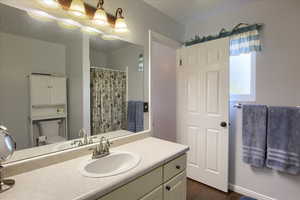 Bathroom with vanity, dark wood-style flooring, and a shower with curtain
