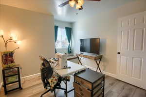 Office space with light wood-style floors and a ceiling fan