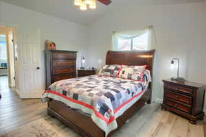 Bedroom featuring light wood-style flooring, ceiling fan, and lofted ceiling
