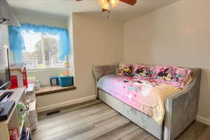 Bedroom with light wood finished floors and a ceiling fan
