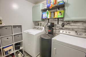 Laundry area featuring cabinet space, washer and dryer, and a textured ceiling
