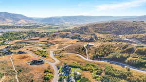 Aerial view of property and surrounding area with a mountainous background