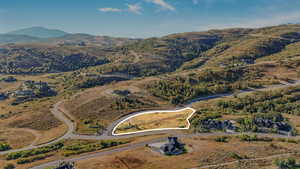 Aerial overview of property's location with a mountain backdrop and property parcel outlined