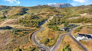 Aerial view of property and surrounding area with a mountain backdrop