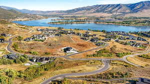 Aerial view of property's location featuring a water and mountain view and nearby suburban area