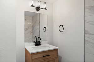 Bathroom with vanity and a textured wall