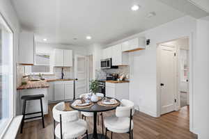 Dining area with dark wood-style flooring and recessed lighting