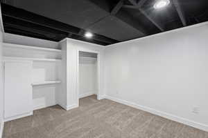 Unfurnished bedroom with light carpet and a closet