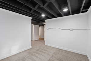 Finished basement featuring light colored carpet and baseboards