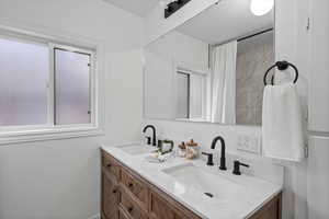 Full bathroom featuring double vanity and curtained shower