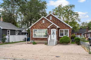 Bungalow featuring brick siding and a chimney