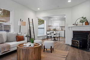Living area with dark wood finished floors, recessed lighting, and a fireplace