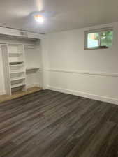 Unfurnished bedroom featuring dark wood-style flooring and a closet