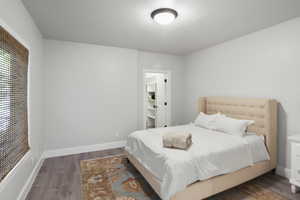 Bedroom featuring dark wood-style flooring and baseboards