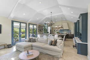 Living room featuring a chandelier, french doors, beamed ceiling, recessed lighting, and high vaulted ceiling