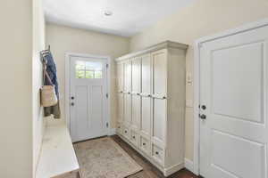 Mudroom featuring dark wood finished floors and baseboards