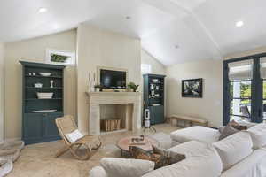 Living area featuring lofted ceiling, a fireplace, french doors, tile patterned flooring, and recessed lighting