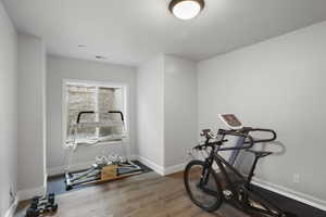 Exercise room with baseboards and wood finished floors