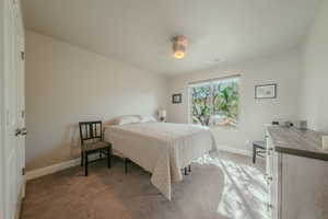 Bedroom with light carpet and a ceiling fan