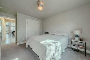 Bedroom with light carpet and a closet