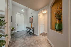 Entrance foyer featuring baseboards and arched walkways